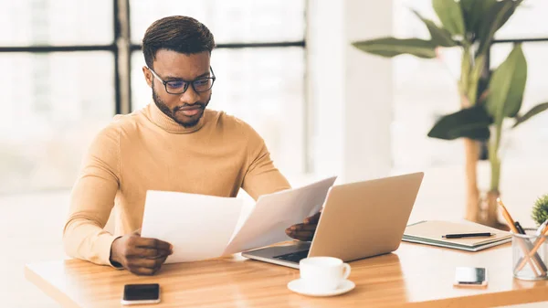 Afro-Amerikaanse manager controleert rapporten in modern kantoor — Stockfoto