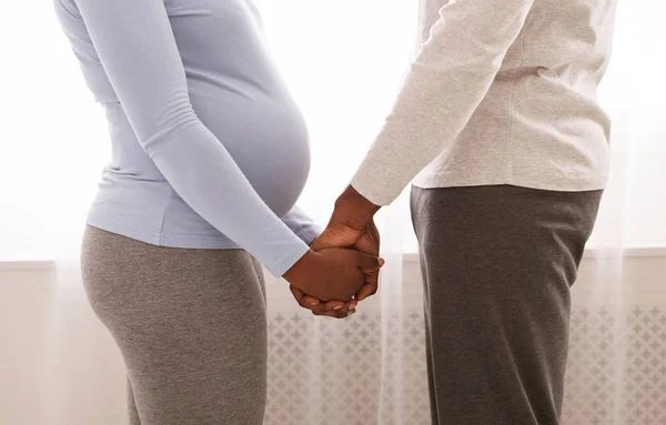 Ostříhaný z černošky těhotný pár drží se navzájem za ruce — Stock fotografie