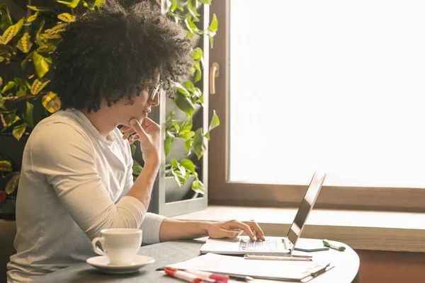 Ung man frilansare bläddrar på laptop sitter i café — Stockfoto