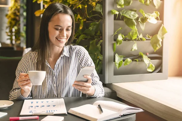 Genç bayan cep telefonundan hoş bir mesaj okuyor. — Stok fotoğraf