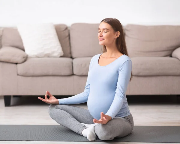 Розслаблена молода вагітна дівчина роздумує на підлозі — стокове фото