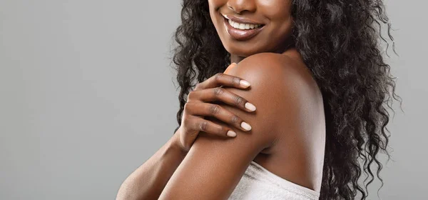 Oigenkännlig svart kvinna njuter av sin släta hud över grå bakgrund — Stockfoto