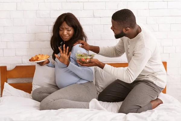 Marido rogando a su esposa embarazada comer alimentos saludables —  Fotos de Stock