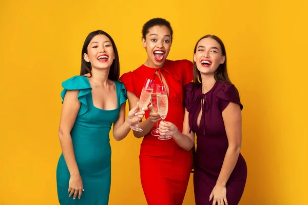 Trzy dziewczyny Clinking Champagne świętowanie Bachelorette stoi nad żółtym tle — Zdjęcie stockowe