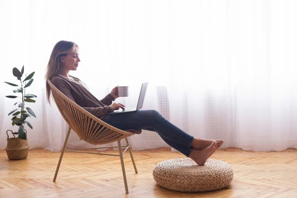 Chica joven en red en el ordenador portátil, relajarse con café —  Fotos de Stock