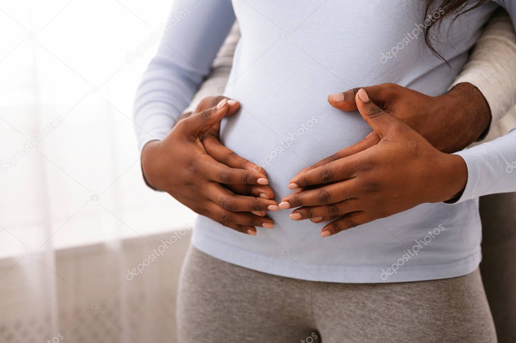 Man and woman hands over pregnant lady belly