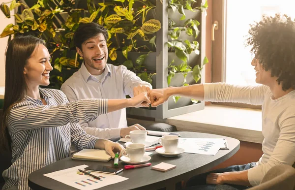 Allegro partner commerciali che fanno pugno urto in caffè — Foto Stock