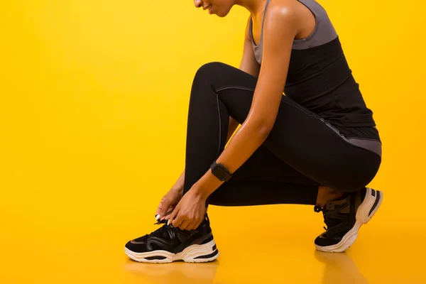 Zapatos de cordones irreconocibles de chica afroamericana sobre fondo amarillo —  Fotos de Stock