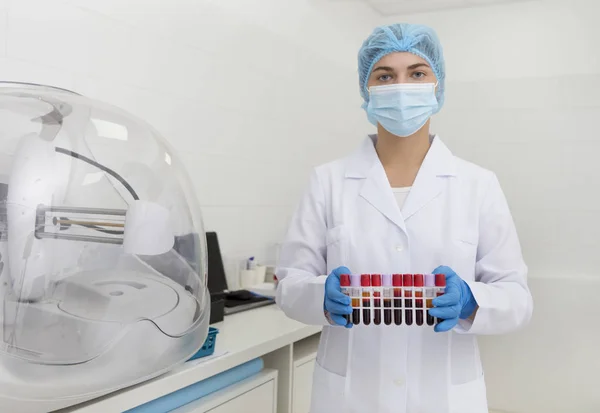 Vrouw in medische kleding bereidt bloedmonsters in reageerbuizen voor — Stockfoto