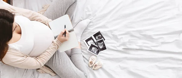 Mujer embarazada haciendo lista de embalaje para el hospital de maternidad — Foto de Stock