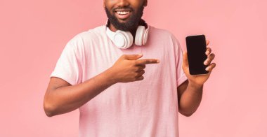 Afro adam boş akıllı telefon ekranını işaret ediyor.