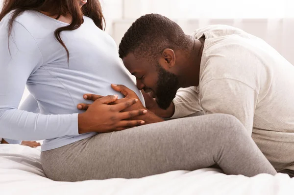 Feliz pai abraçando grávida mulher barriga e beijando — Fotografia de Stock