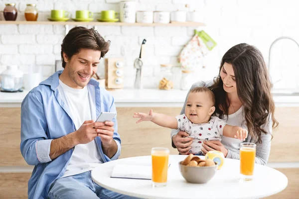 Millennial homme textos au téléphone, dîner avec femme et bébé — Photo