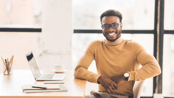 Hombre afroamericano feliz sentado con portátil — Foto de Stock