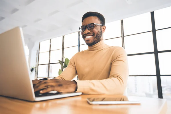 Sourire noir guy à flexible bureau dactylographier sur clavier — Photo