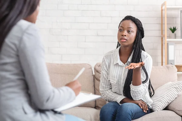 Szomorú afro-amerikai nő megosztja a problémáit a tanácsadói irodában. — Stock Fotó