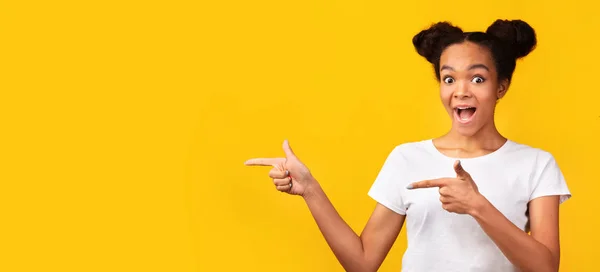 Attractive black teen pointing fingers at free space — Stock Photo, Image