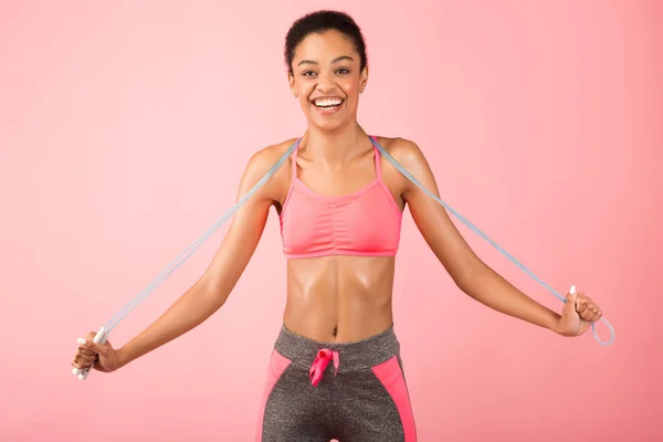 African American Woman Holding Jump Rope Posing Over Pink Background — Stock Photo, Image