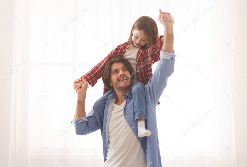 Cute little girl playing with her cheerful father