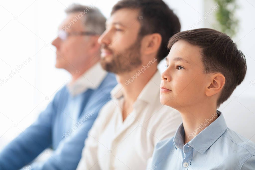 Boy Sitting Next To Father And Grandfather At Home