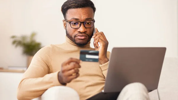 African american man calling to bank shopping online at home — Stock Photo, Image