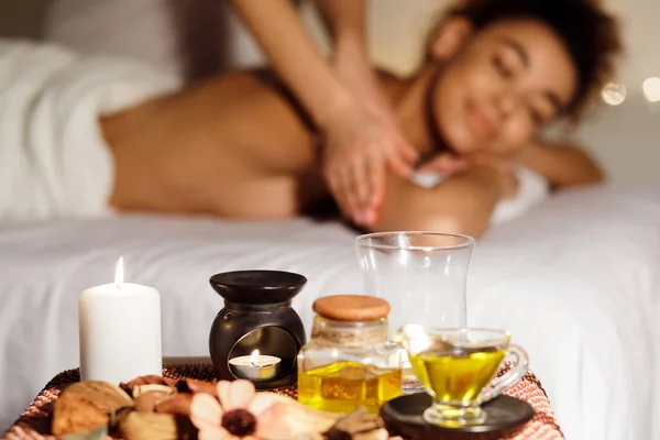 Mulher feliz recebendo massagem com vela de aroma e óleos — Fotografia de Stock