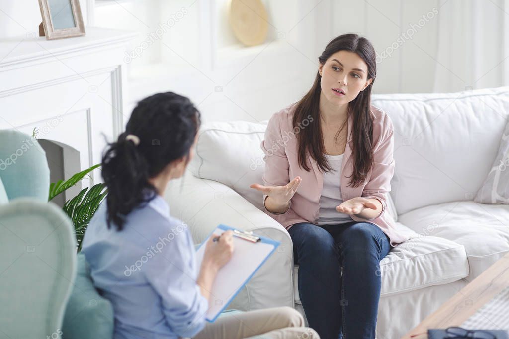 Emotional woman sharing her feelings with therapist