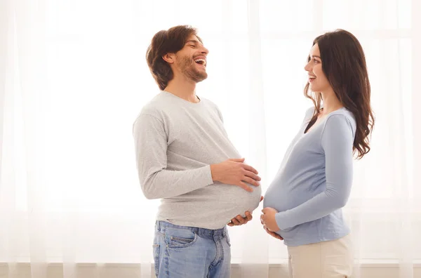 Lustiges Porträt einer schwangeren Frau und ihres Mannes mit falschem Bauch — Stockfoto