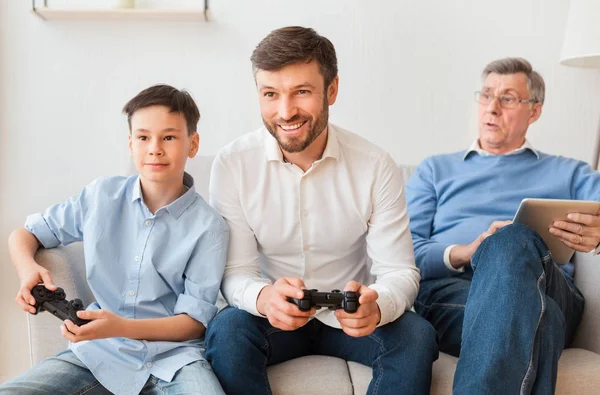 Mann spielt Videospiele mit Sohn und älterem Vater — Stockfoto