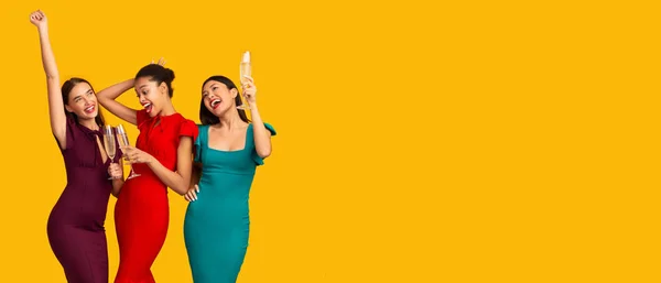 Three Elegant Girls Dancing With Champagne Over Yellow Background, Panorama