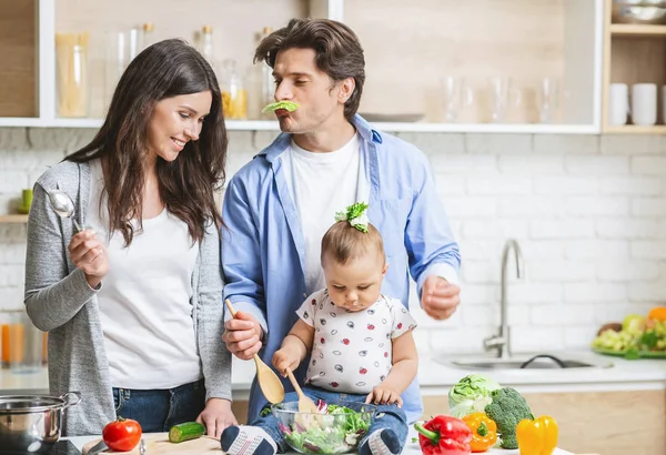 Verspielter Papa bereitet Mittagessen mit Frau und Baby-Sohn zu — Stockfoto