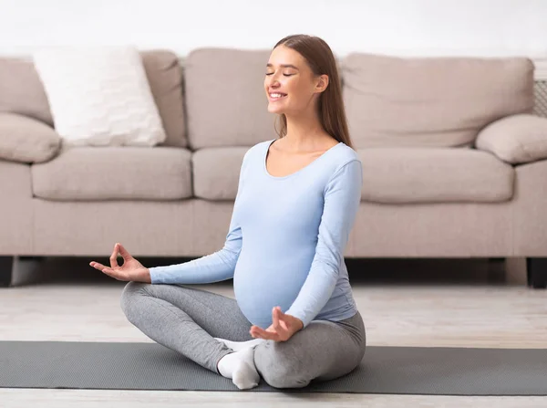 Feliz joven expectante meditando en el suelo — Foto de Stock