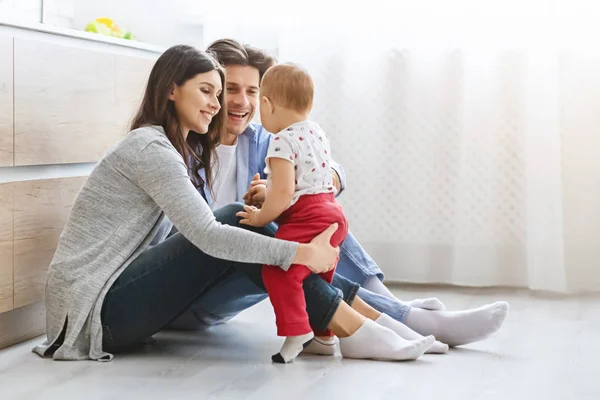 Allegro mamma e papà giocare con bambino figlio sul pavimento della cucina — Foto Stock