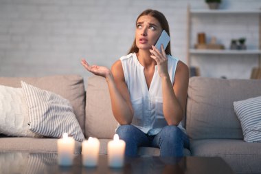 Kız, erkek arkadaşını arıyor. Onu bekliyor. Evde oturuyor.