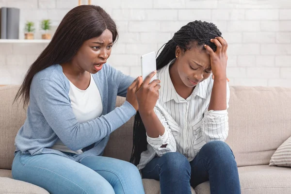 Upset Afro Girl Showing Smartphone With Bad Message To Her Friend — ストック写真