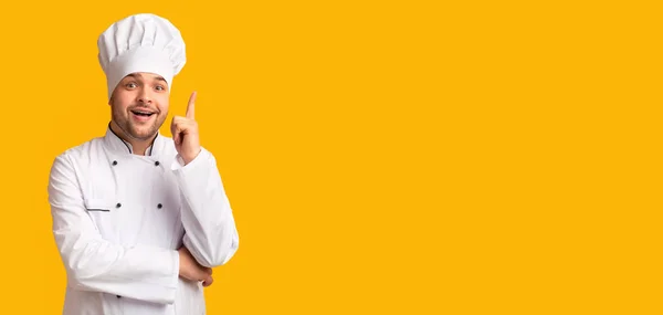 Nadšený kuchař ukazující prst nahoru přes žluté pozadí, Panorama — Stock fotografie