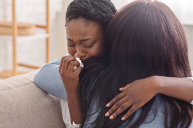 Woman hugging her crying girlfriend, supporting her after receiving bad news clipart