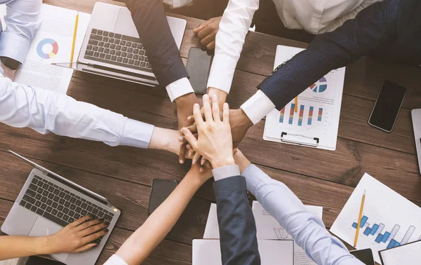 Equipe de negócios multiétnica empilhando as mãos juntas na reunião — Fotografia de Stock