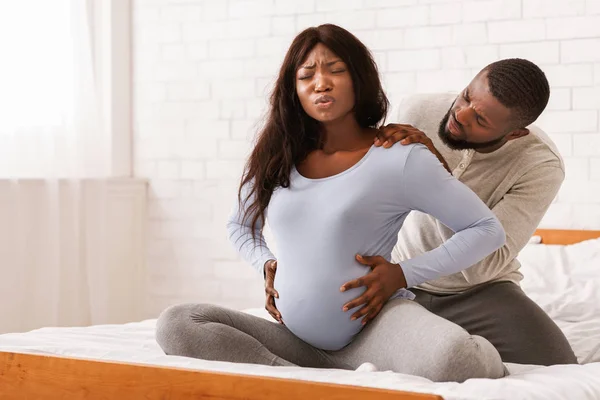 Gravid dam som lider av ryggvärk, make masserar sina axlar — Stockfoto