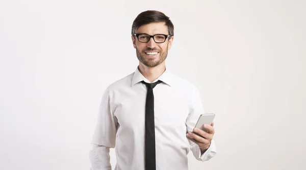 Sorrindo homem usando telefone celular em pé sobre fundo branco, Panorama — Fotografia de Stock