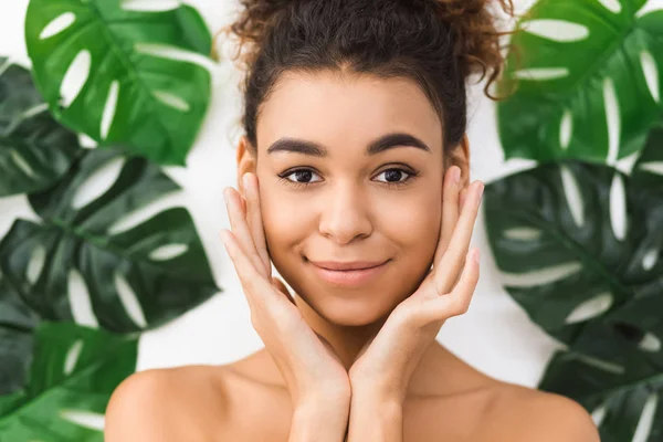 Cosmetologisch concept. Afro-Amerikaanse vrouw tegen tropische bladeren — Stockfoto