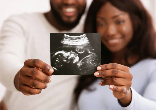 Afro çift, bebeklerinin ultrason görüntülerini gösteriyorlar. — Stok fotoğraf