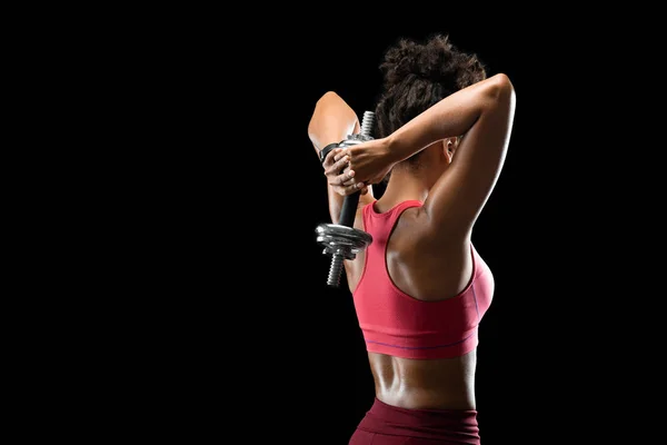 Zwart atletisch meisje werken op haar rug spieren met behulp van lange halter — Stockfoto