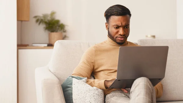 집 소파에서 노트북을 사용하는 흑인 남자 — 스톡 사진