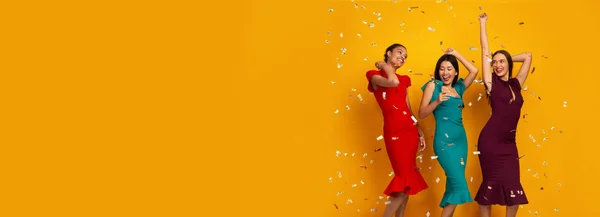 Trois filles heureuses en robes s'amusant avec Confetti, Studio — Photo