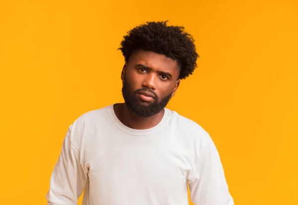 Hombre negro serio posando sobre fondo naranja — Foto de Stock