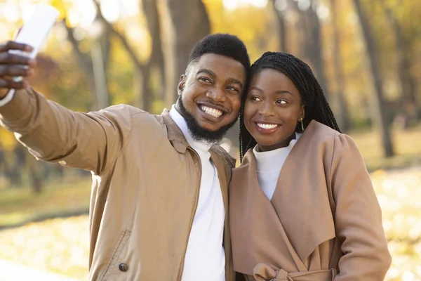 Romantiskt afro par tar selfie, poserar tillsammans på datum utomhus — Stockfoto