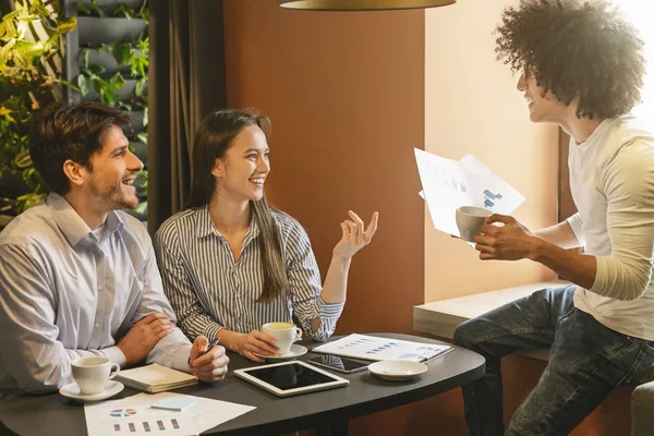 Jonge partners bespreken grafieken in café, lege ruimte — Stockfoto