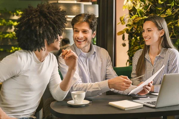 Felice business team discutendo proficuo rapporto annuale in caffè — Foto Stock