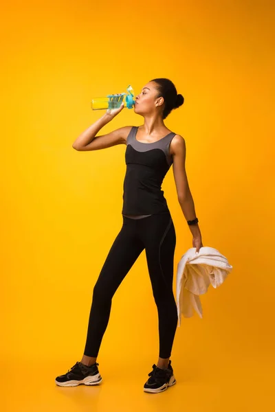 Desportivo afro-americano senhora beber água durante o treino no estúdio — Fotografia de Stock